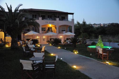 a building with tables and chairs and a pool at Land of Gods in Gythio