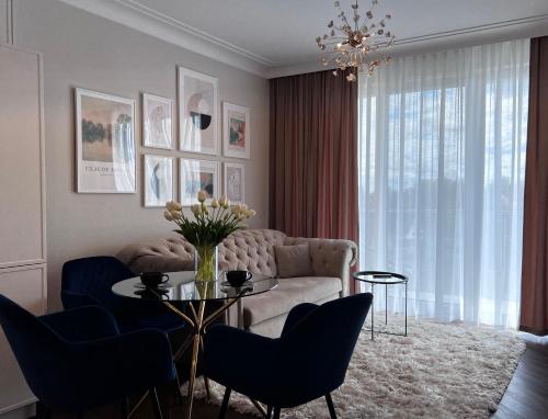 a living room with a couch and a table and chairs at Nr 12 EUROPA22 Exclusive z Garażem podziemnym in Tomaszów Mazowiecki