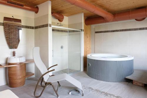 y baño con bañera y silla. en Hotel Le Botti, en Guarene