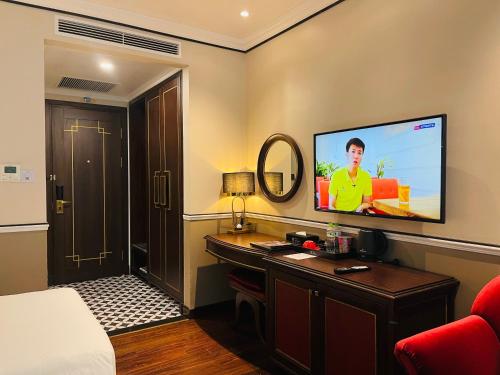 a hotel room with a bed and a flat screen tv at Hotel du Monde Art in Hanoi