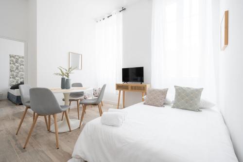 biały pokój z 2 łóżkami i stołem w obiekcie Le Complexe Concorde - 3 Apartments 16 pers Vélodrome Terrasse Clim w Marsylii