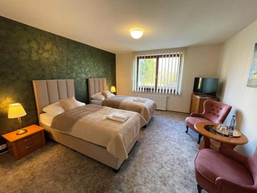 una habitación de hotel con 2 camas y una silla en TATRANSKY DOM sk, en Veľký Slavkov