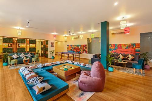 a large living room with couches and tables at Zostel Plus Rishikesh, Mohanchatti in Rishīkesh