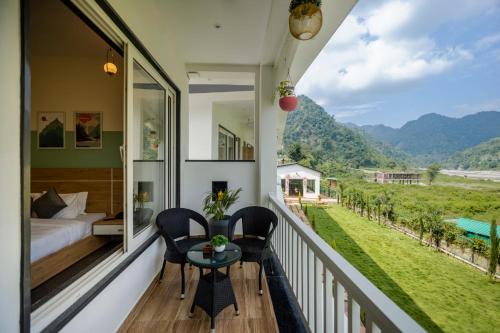 a balcony with a bed and a table and chairs at Zostel Plus Rishikesh, Mohanchatti in Rishīkesh