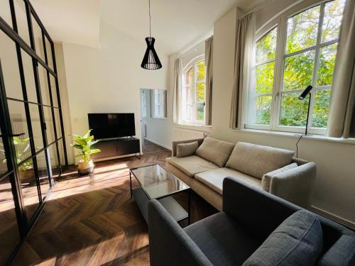 a living room with a couch and a tv at Ferienwohnungen an der Salvatorkirche - Exklusiv-Apartments mit Terrasse in Coburg