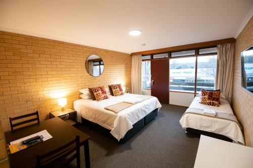 Habitación de hotel con 2 camas y ventana en Bentley's Hotel en Clare