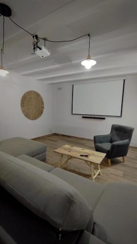 a living room with a couch and a table and a screen at masia riu dels arbres in Benasal