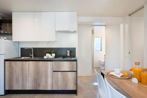 a kitchen with white cabinets and a wooden counter top at Camping Il Capannino Glamping Village in Marina di Bibbona