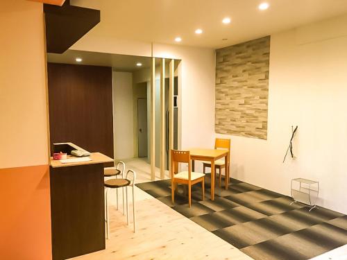 a kitchen and dining room with a table and chairs at Relak Guest House 登別 Station in Noboribetsu