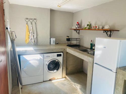 a kitchen with a washing machine and a sink at Wild Fig Guesthouse in White River