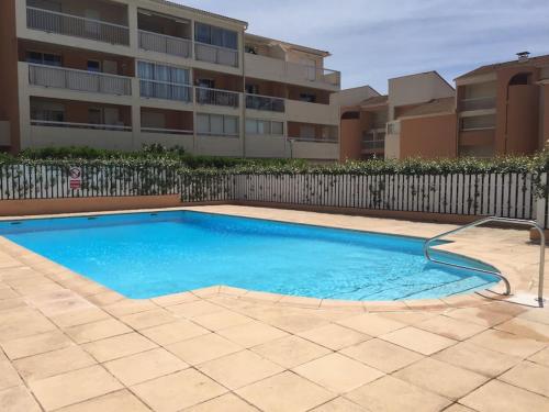 une piscine devant un immeuble dans l'établissement La vie en Rose, à La Seyne-sur-Mer