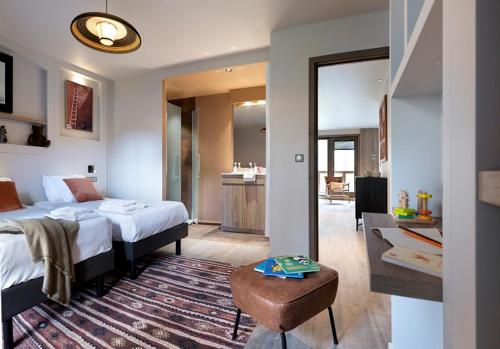 a bedroom with a bed and a living room at Résidence Ynycio in Tignes