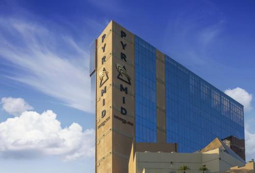 a tall building with a clock on the side of it at Pyramid Continental Hotel in Juba