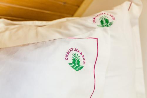 a white shirt with green logos on it at Chalet Liza & Rozi in Zgornja Ložnica