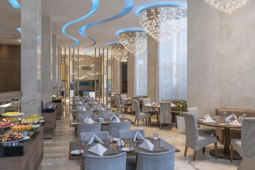 a dining room with tables and chairs and chandeliers at Pyramid Continental Hotel in Juba