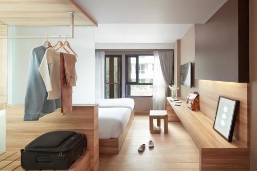 
a hotel room with a bed, dresser and a dresser at Happy 3 in Bangkok
