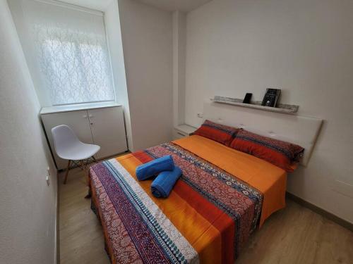 a bedroom with a bed and a chair and a window at El Palmar in Murcia