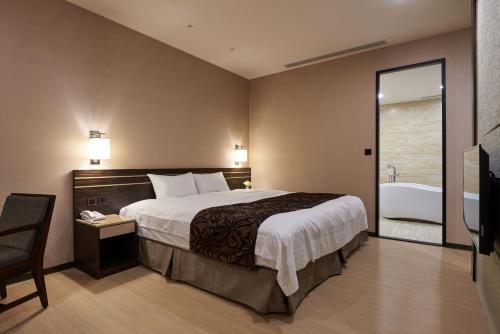 a bedroom with a bed and a bath tub and a sink at SOL Hotel in Hsinchu City