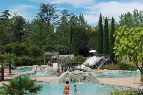 - 2 enfants dans une piscine dans un parc aquatique dans l'établissement Appartement terrasse centre Nyons, à Nyons