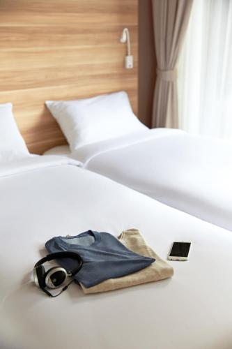 a pair of glasses and a bag sitting on a bed at Happy 3 in Bangkok