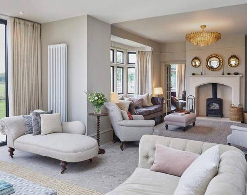 a living room with white furniture and a fireplace at The Lakes By YOO in Lechlade