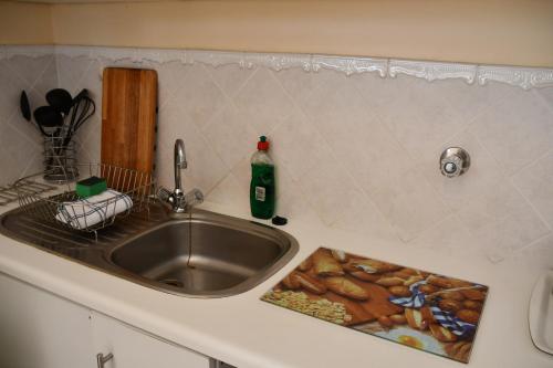 a kitchen counter with a sink and a bottle on it at Bradclin Sport Newlands in Cape Town