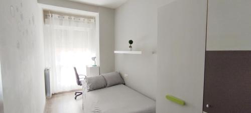 Habitación blanca con sofá y ventana en Los Soportales en Soria
