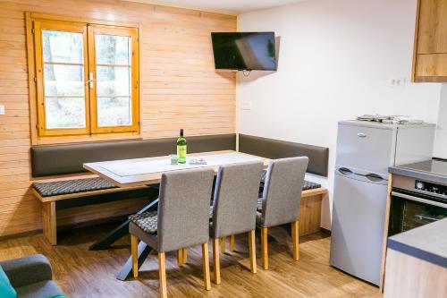 a kitchen with a table and chairs and a refrigerator at Chalet Liza & Rozi in Zgornja Ložnica