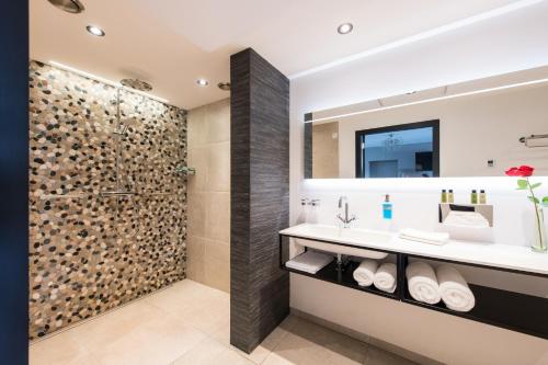 a bathroom with a shower and a sink at B&B de Maaskei in Guelle