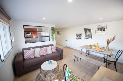 ein Wohnzimmer mit einem Sofa und einem Tisch in der Unterkunft KASA HOME - Calme, Cosy, WIFI & Netflix in Saint-Martin-la-Plaine