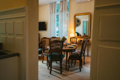 a dining room with a table and chairs and a mirror at Domaine Bohème I art de vivre in Guebwiller