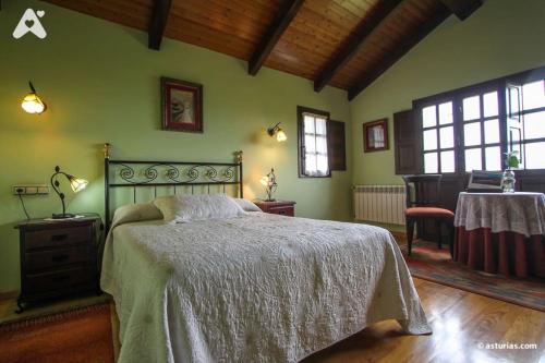 Schlafzimmer mit einem Bett, einem Tisch und Fenstern in der Unterkunft Casa Rural La Cuesta in Villarmil