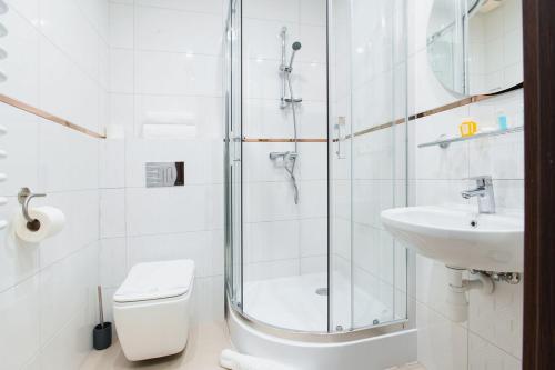 a bathroom with a shower and a toilet and a sink at Hotel Poniatowski in Radom