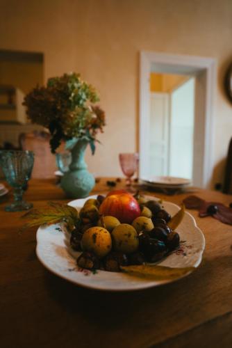a plate of fruit on a wooden table at Domaine Bohème I art de vivre in Guebwiller