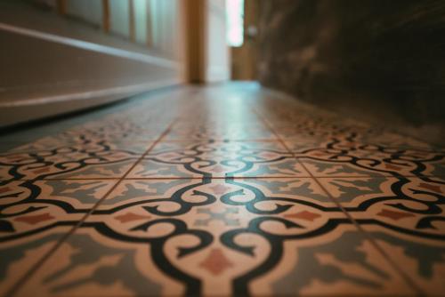 a hallway with a tile floor with a design on it at Domaine Bohème I art de vivre in Guebwiller