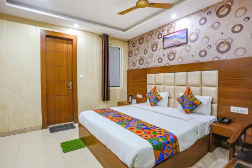 sypialnia z dużym łóżkiem i drewnianymi drzwiami w obiekcie FabHotel Frolic w mieście Haridwar