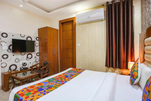 a bedroom with a bed and a television in a room at FabHotel Frolic in Haridwār