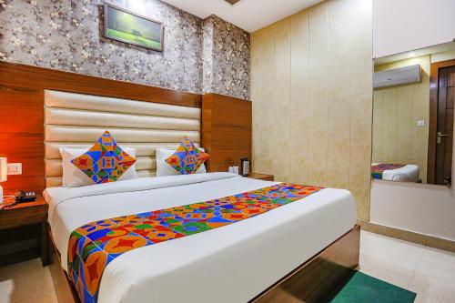 a bedroom with a large bed with a colorful blanket at FabHotel Frolic in Haridwār