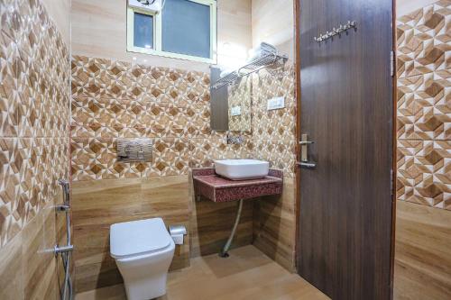 a bathroom with a toilet and a sink at FabHotel Frolic in Haridwār