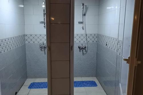 baño con ducha y puerta de cristal en The Legend Villa فيلا الاسطوره, en Sowayma