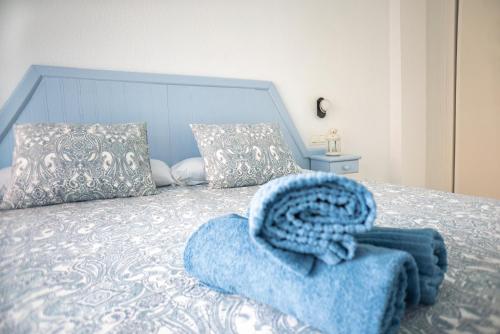 - une chambre avec un lit à tête bleue dans l'établissement Apartamentos El Velero, à Torremolinos