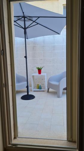 a patio with an umbrella and chairs and a table at LITHOS ROOMs in Matera