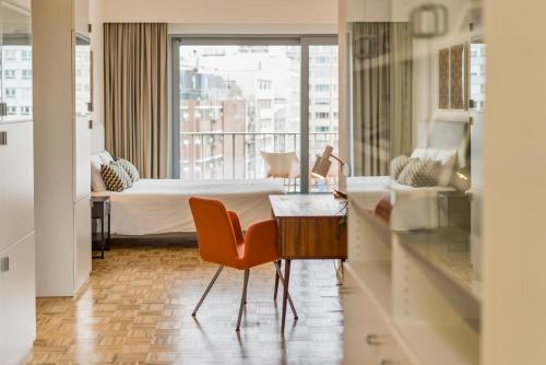 um quarto de hotel com uma cama, uma mesa e cadeiras em Fuths Loft Penthouse 85 em Antuérpia