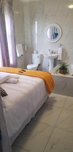 una camera con letto, lavandino e servizi igienici di Ko-Porch luxury guest house a Polokwane
