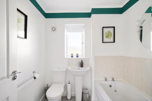 a bathroom with a white toilet and a sink at Ideal 3 bed House in Wolverhampton - Parking in Wolverhampton