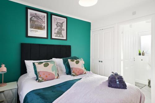 una camera da letto con pareti verdi e un letto con cuscini di Ideal 3 bed House in Wolverhampton - Parking a Wolverhampton