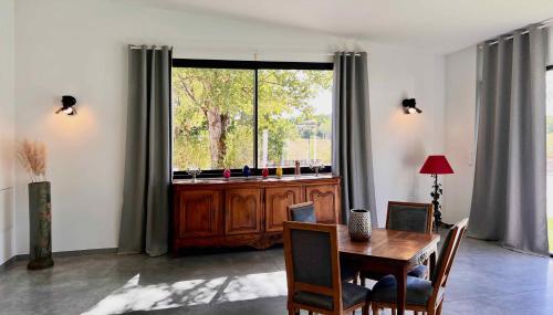 a dining room with a table and a large window at L'atelier Insolite - Piscine chauffée in Montauban