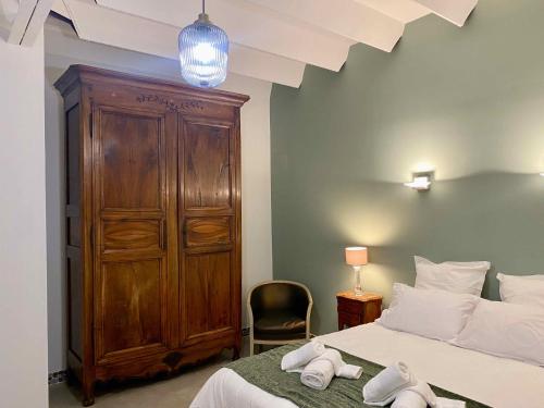 Schlafzimmer mit einem Bett und einem Holzschrank in der Unterkunft L'atelier Insolite - Piscine chauffée in Montauban