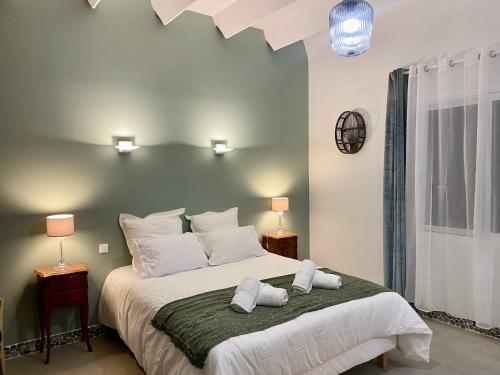 a bedroom with a large white bed with two lamps at L'atelier Insolite - Piscine chauffée in Montauban
