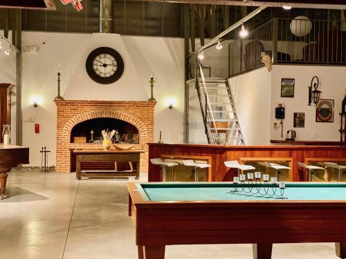 a pool table in a room with a clock on the wall at L'atelier Insolite - Piscine chauffée in Montauban